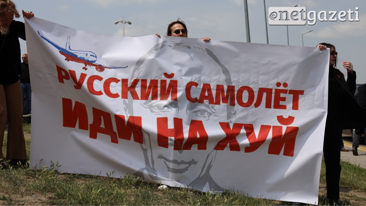 Protestors near the airport in Tbilisi hold a sign saying "Russian airplane, go fuck yourself." (Photo from Netgazeti)